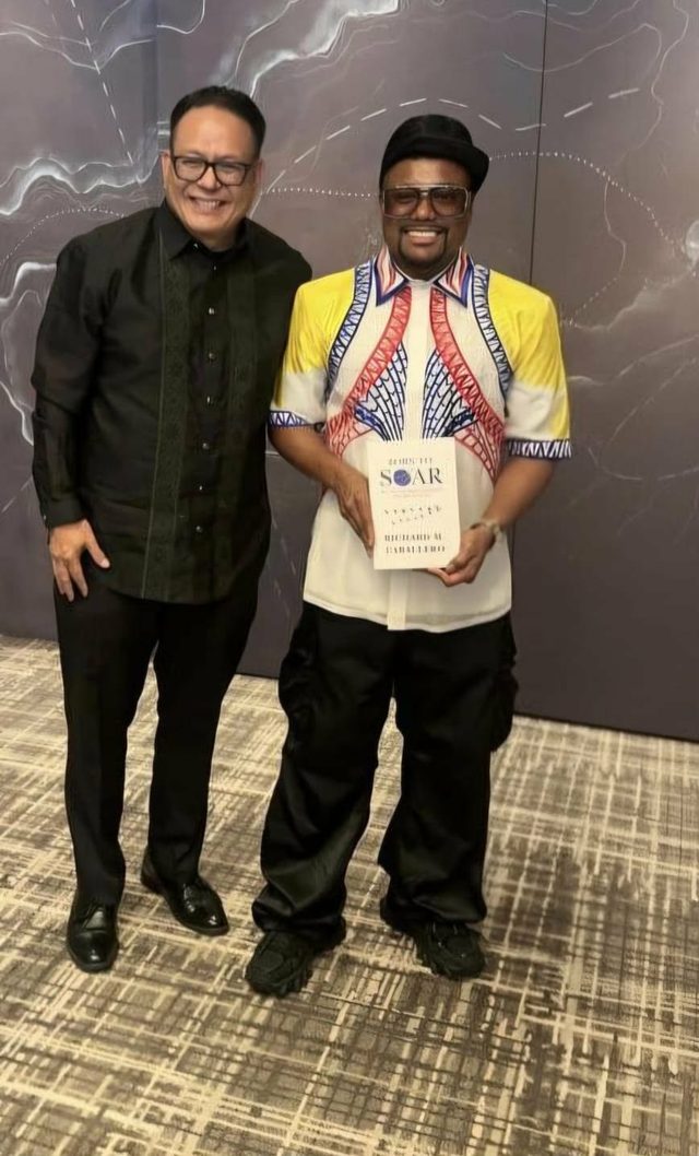 apl.de.ap holding a copy of Born to Soar at the Sama Sama gala in Toronto
